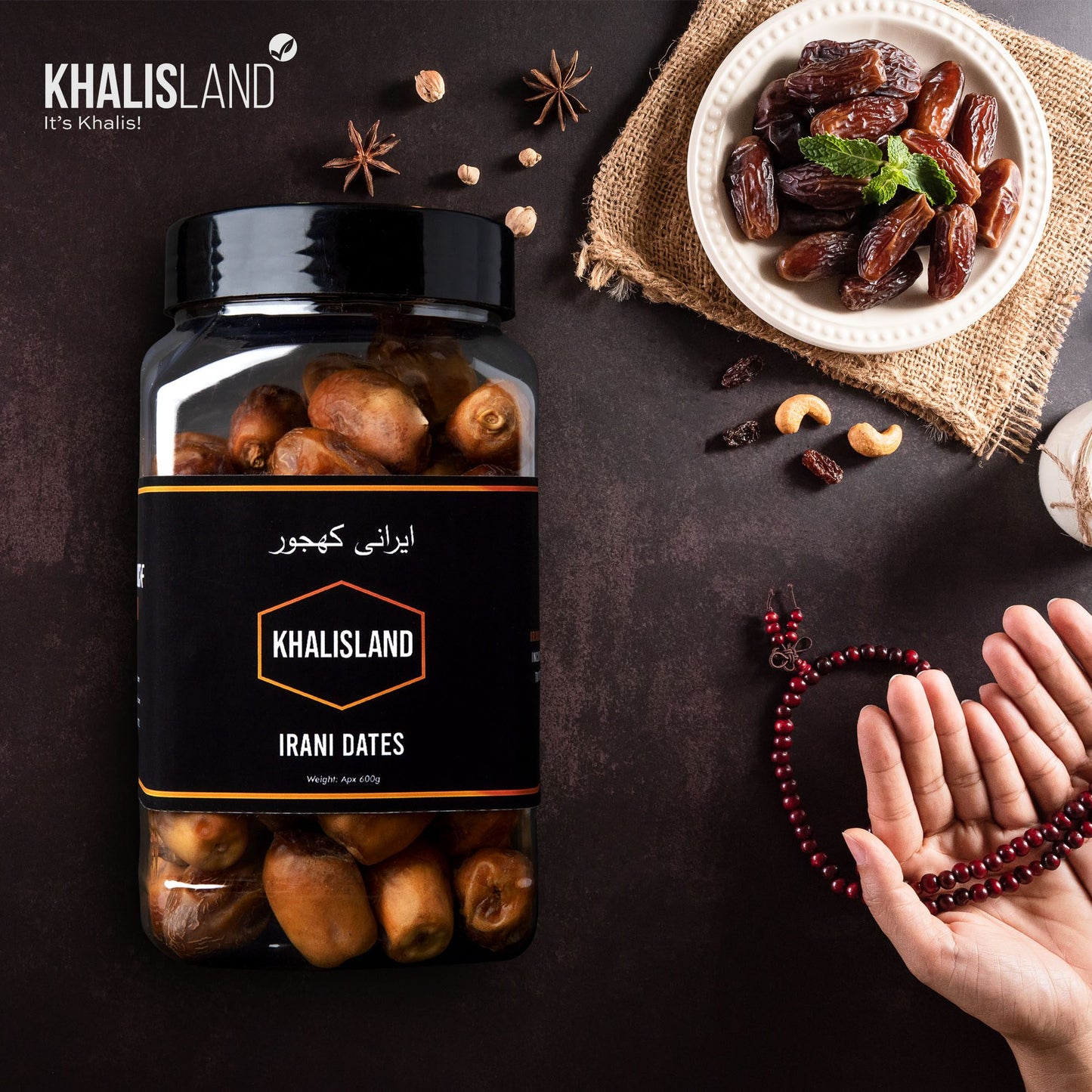 A container of Khalisland Irani Dates on a table, with the brand name visible, alongside a plate of dates in front and a person's hands holding a bracelet.