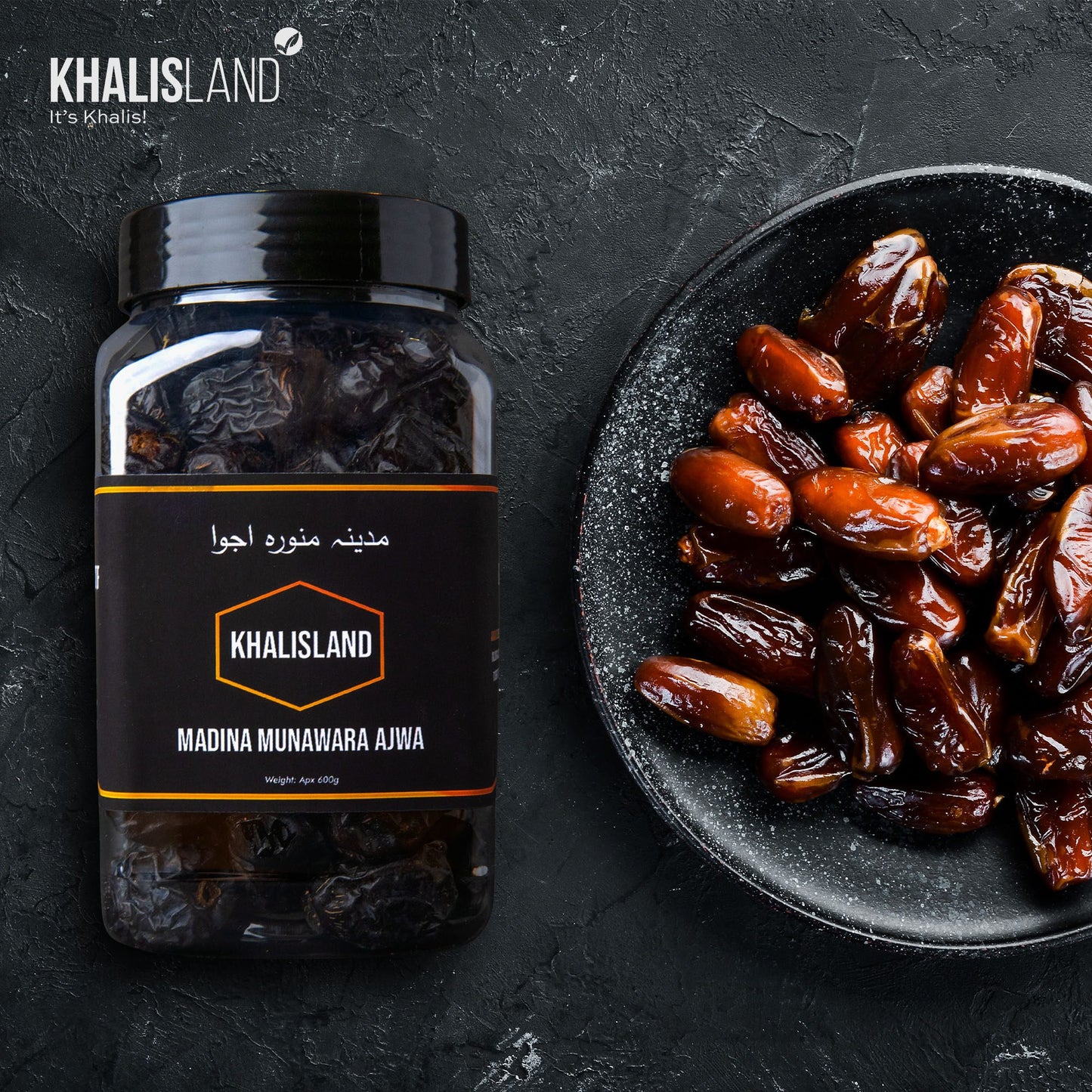 A jar of Khalisland Madina Munawara Ajwa dates with the label visible, showing the product name and the dates outside the jar on a dark background.