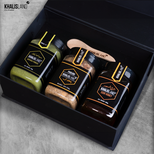 A black box containing three jarred products labeled Moringa Powder, Beri Honey, and Panjeeri, with a wooden spoon in the top of the box.